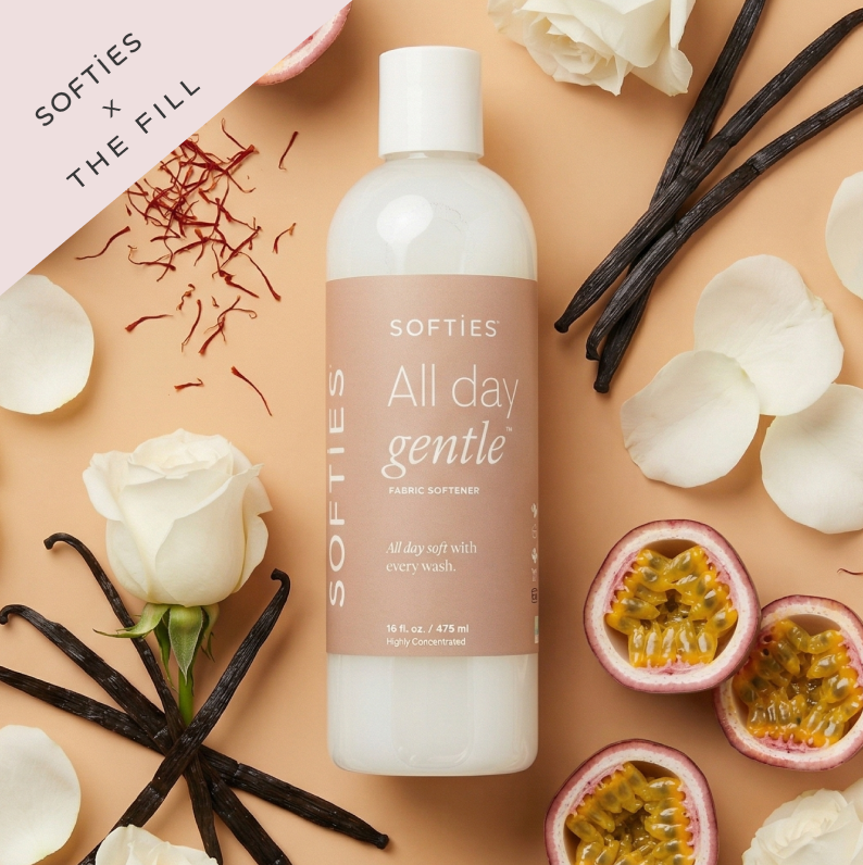 All Day Gentle™ Fabric Softener Fabric softener bottle labeled 'All day gentle' surrounded by flowers and vanilla beans on a beige background